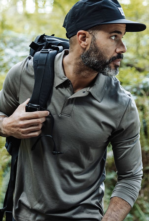 man wearing merino polo with a backpack