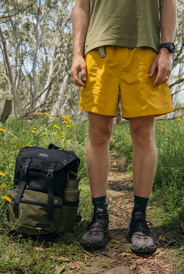 Man wearing yellow shorts standing outdoors