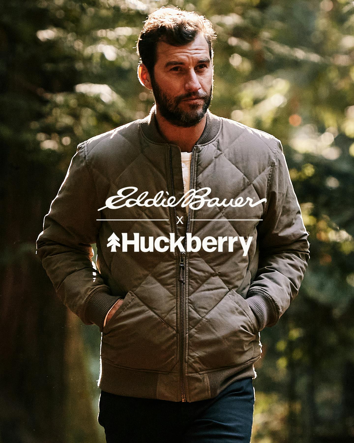 Man in Woods Wearing Jacket with Huckberry and Eddie Bauer logo on top