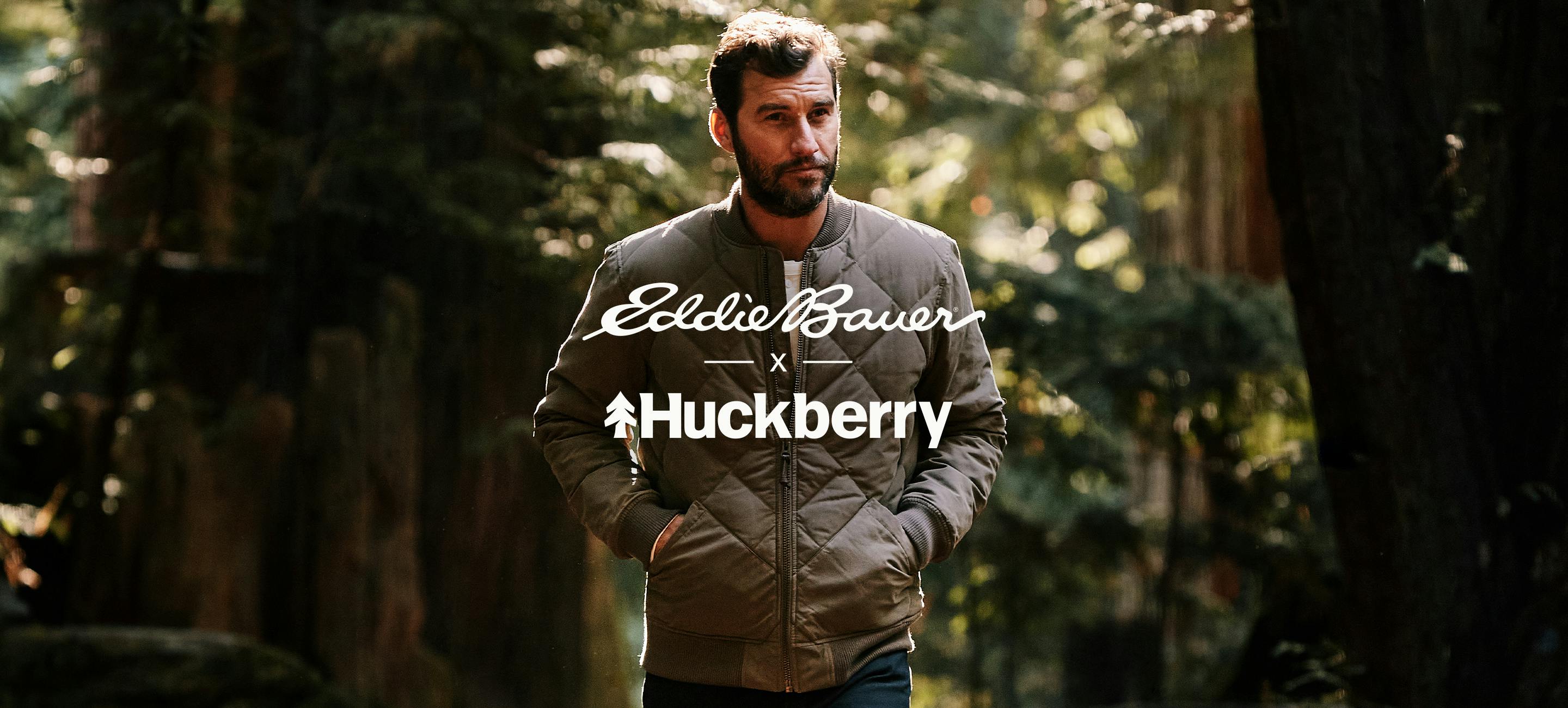 Man in Woods Wearing Jacket with Huckberry and Eddie Bauer logo on top