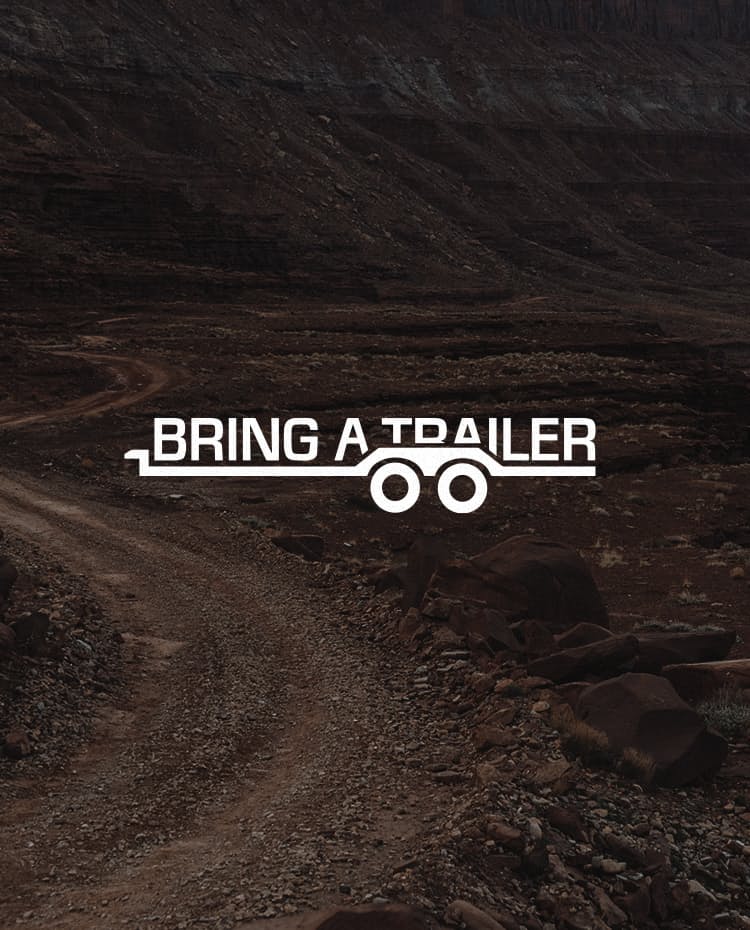 Bring A Trailer logo over desert landscape