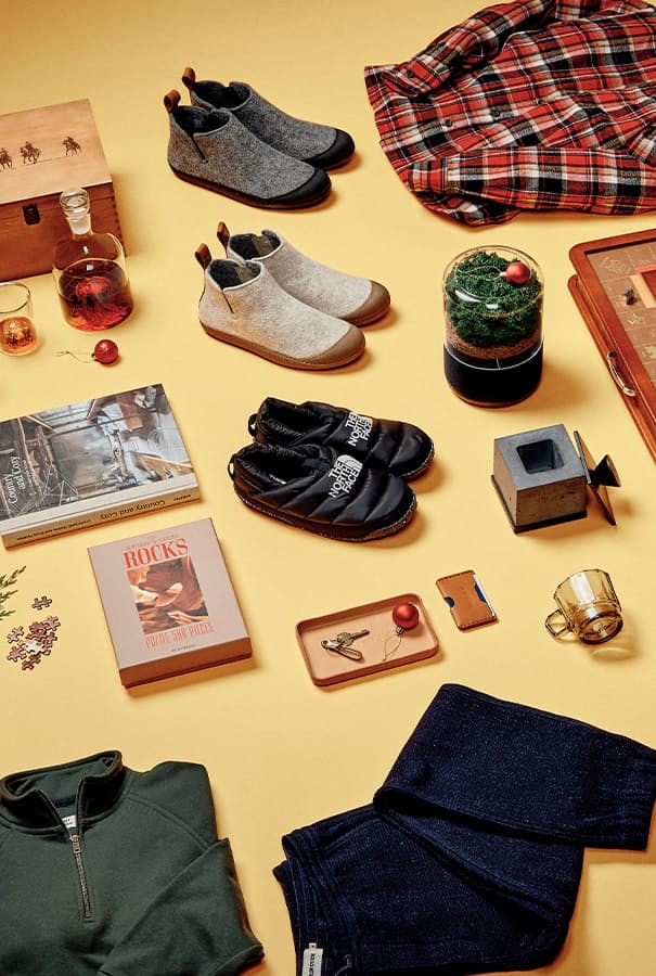 Studio image of objects including monopoly set, slippers, and whiskey glasses