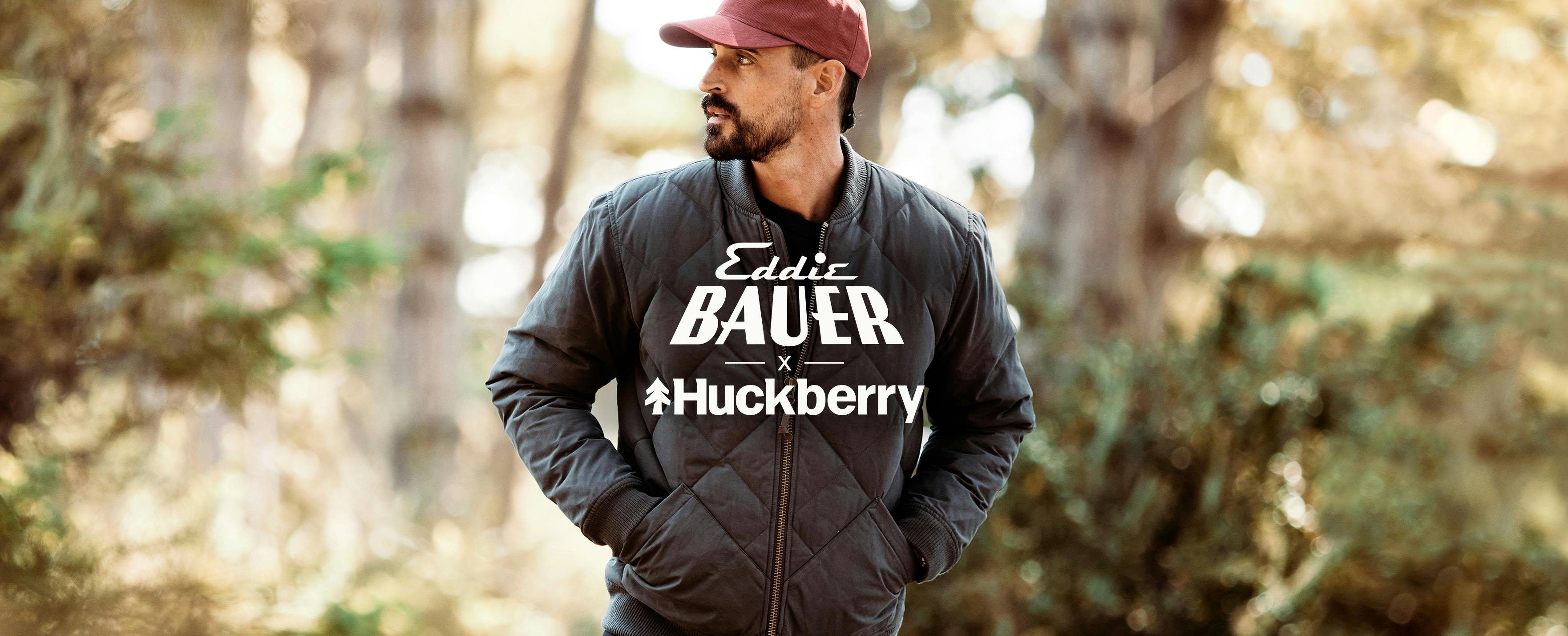 Man in Woods Wearing Jacket with Huckberry and Eddie Bauer logo on top of image